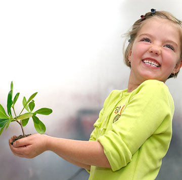 little girl holding small plant